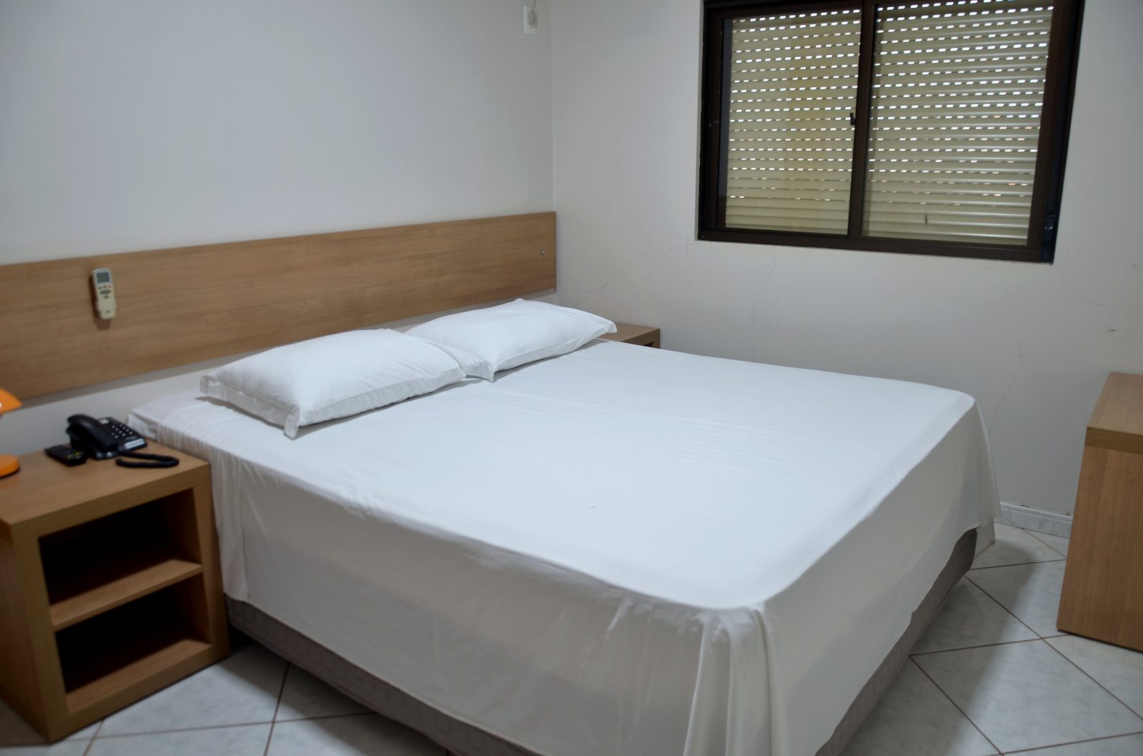 Quarto Luxo do Treville Hotel com ar-condicionado, frigobar e cabeceira em madeira