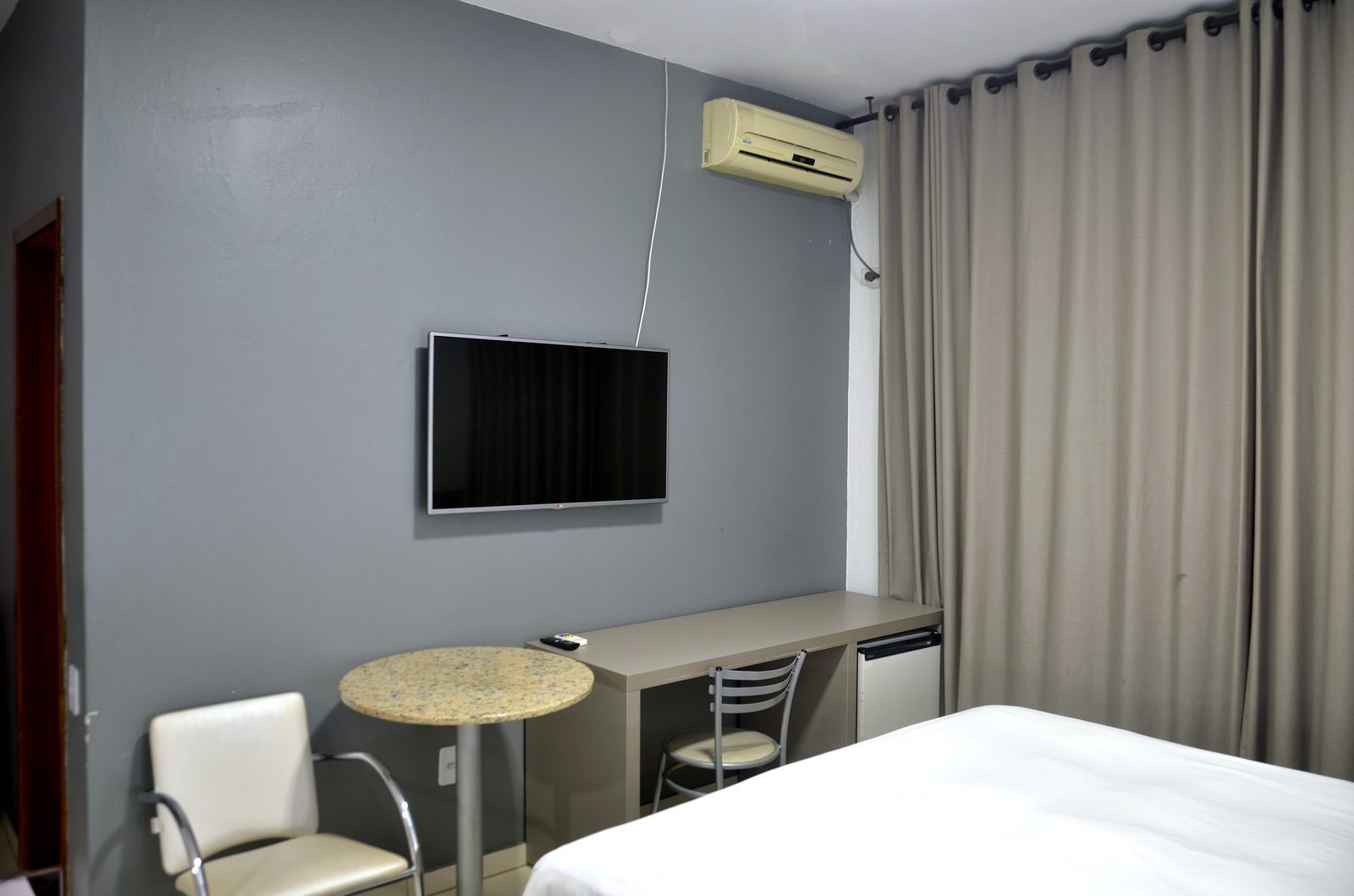 Quarto executivo com escrivaninha e ar-condicionado