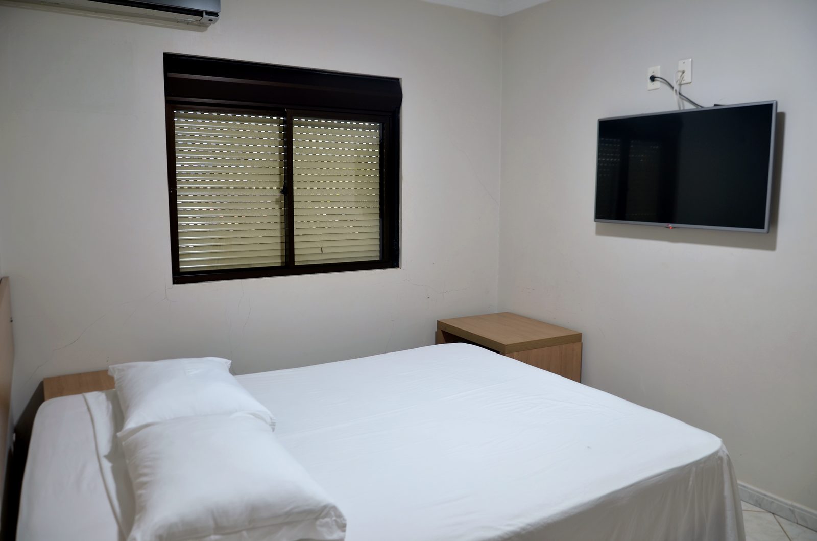 Quarto Standard do Treville Hotel Carazinho com cama de casal e janela ampla